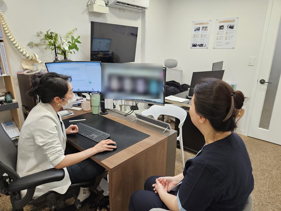 원장이 야누스 피부 분석 결과를 환자와 함께 모니터로 보며 상담하는 장면